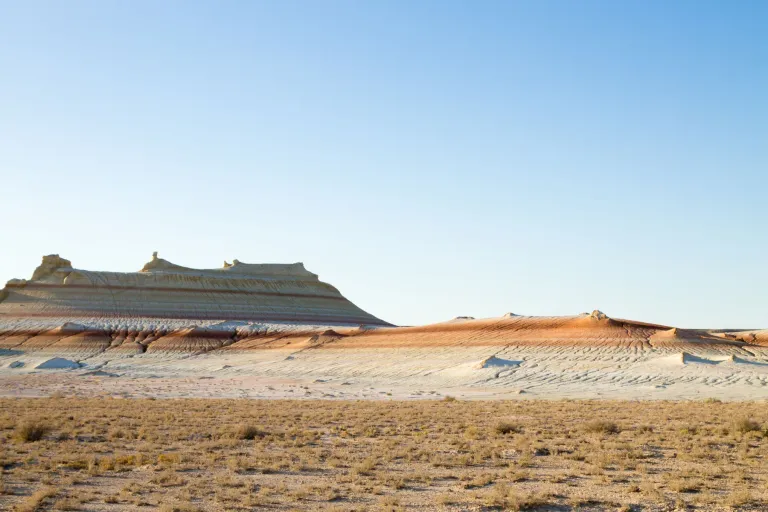 Layered desert mesas above a dry grass-covered plain