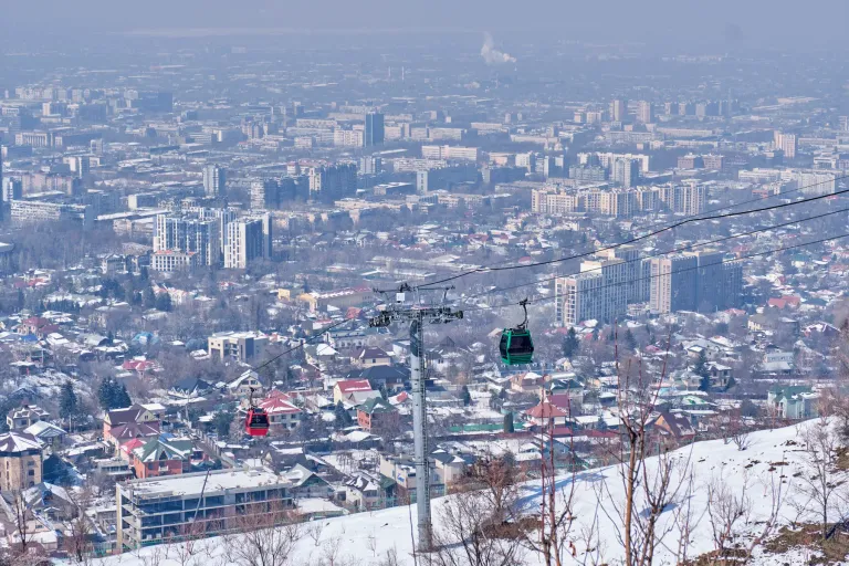 Kok-Tobe cable cars above snow-covered Almaty rooftops