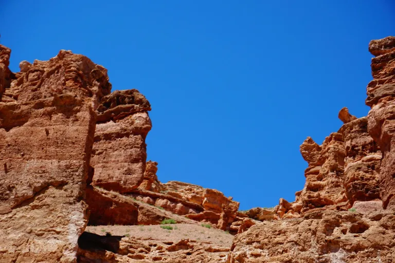 Close view of red sandstone towers beneath a blue sky in Charyn Canyon