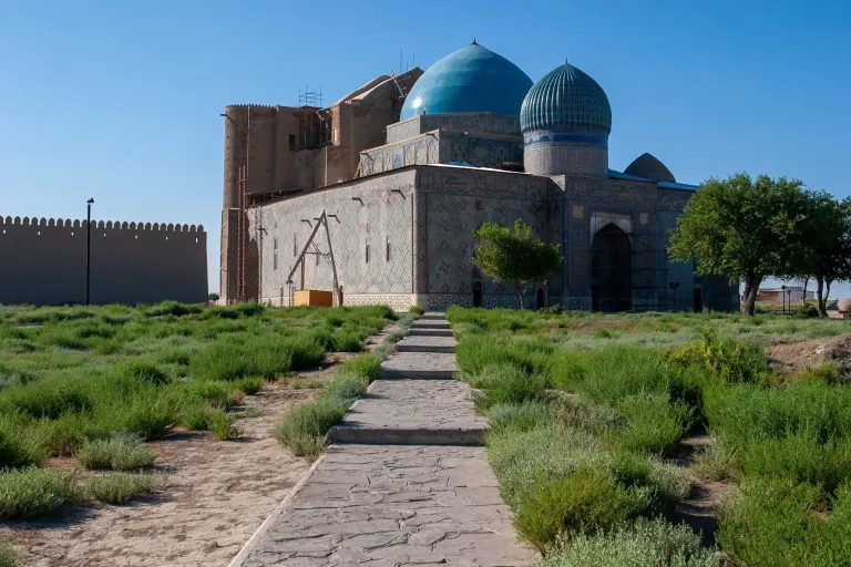 Stone path leading toward a historic building with blue domes