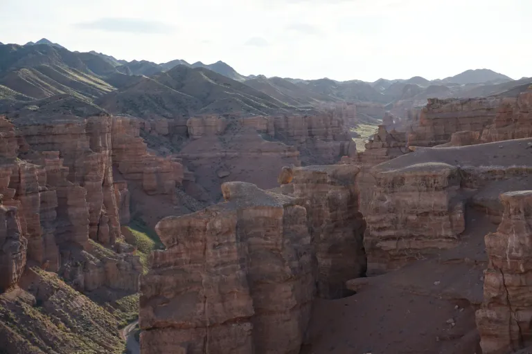 Panoramic view of layered sandstone cliffs and rock towers in Charyn Canyon