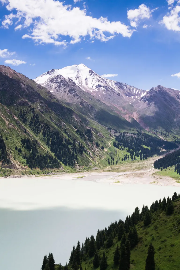 Pale turquoise Big Almaty Lake below steep snow-covered peaks