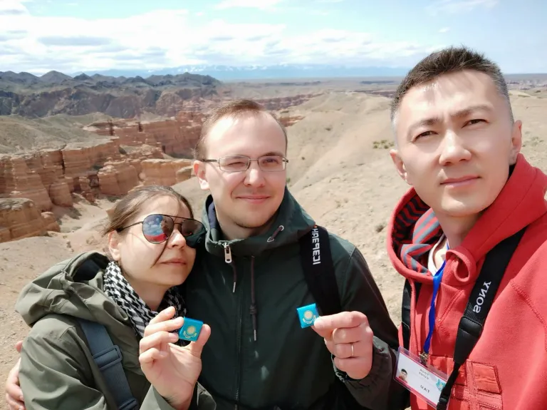 Travellers posing at a viewpoint above Charyn Canyon