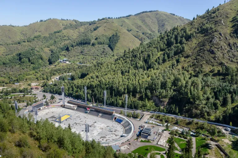 View over a winding road and buildings among forested mountain slopes