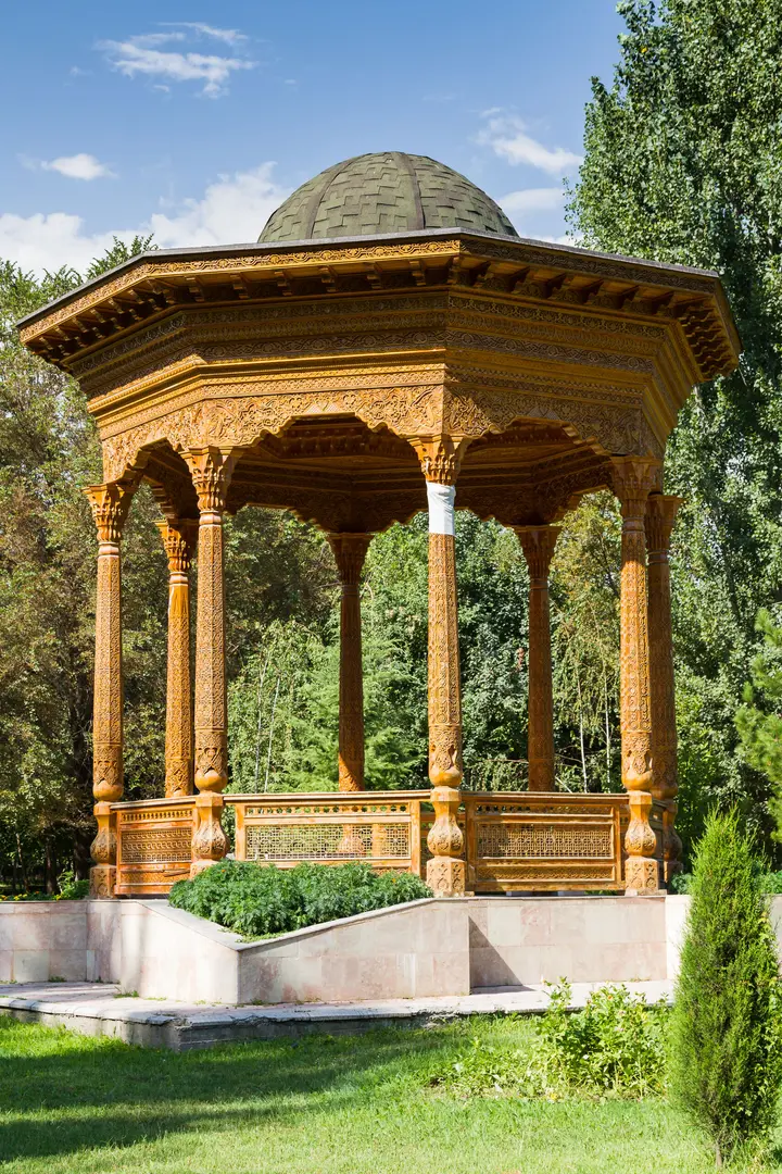 Carved wooden pavilion among trees in a Dushanbe park